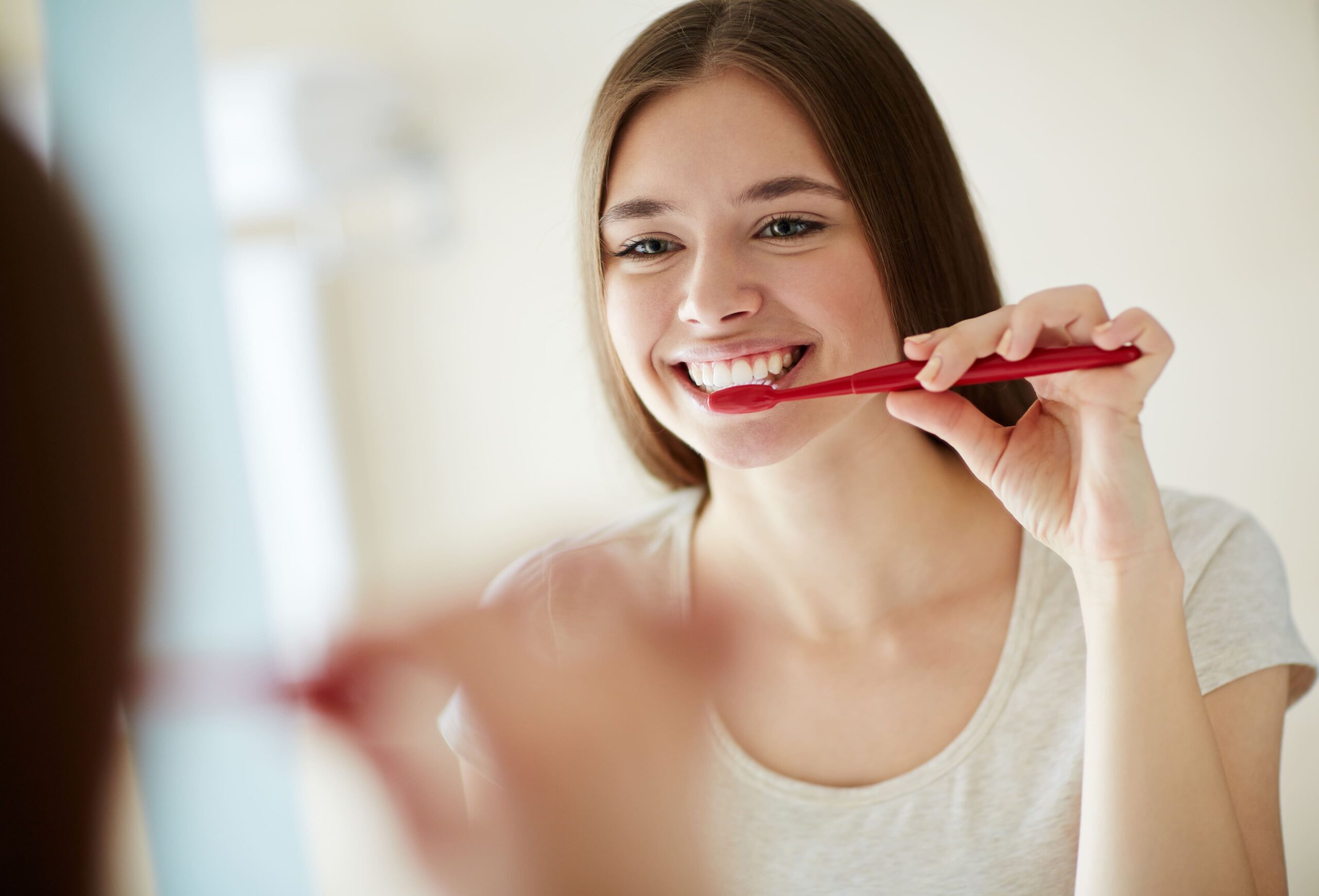 mulher escovando lente de contato dentária