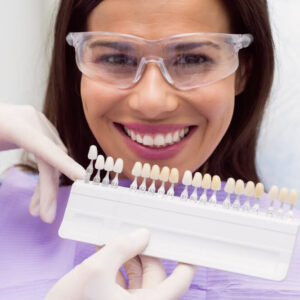 mulher no dentista escolhendo tipos de tons porcelana